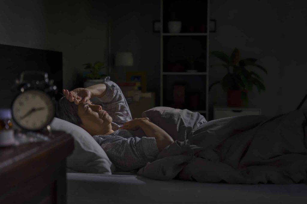Patient struggling to sleep after surgery with proper positioning support demonstrating quality rest for faster healing