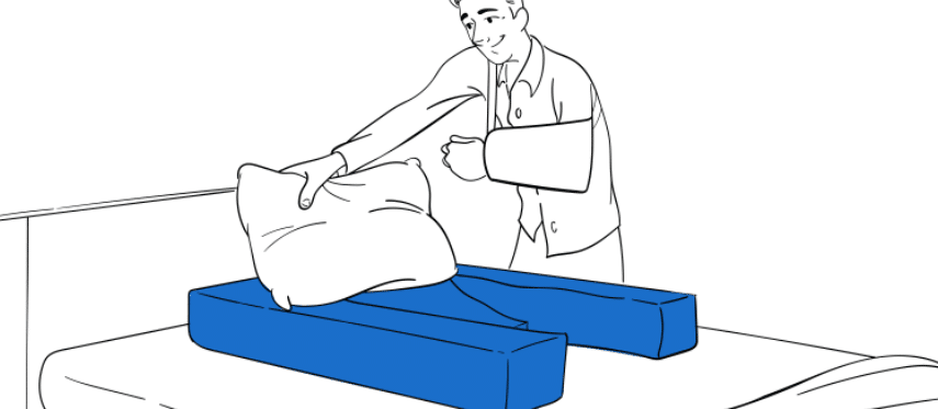 Doctor demonstrating Restore You shoulder surgery recovery support positioning on bed