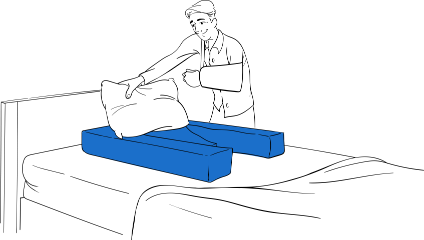Doctor demonstrating Restore You shoulder surgery recovery support positioning on bed