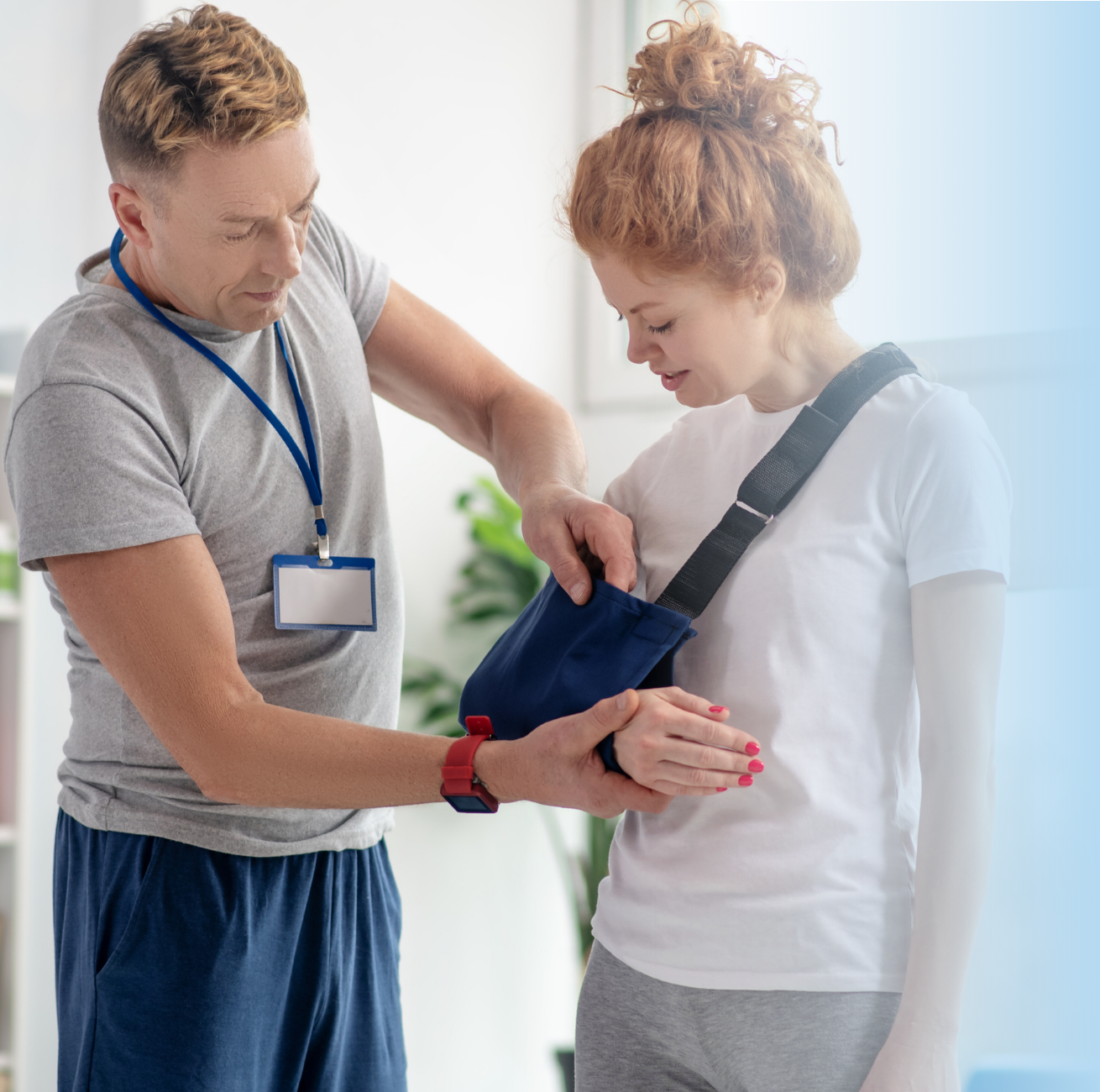 Physical therapist demonstrating proper shoulder positioning in maximally loose packed position for post-surgical support with arm sling