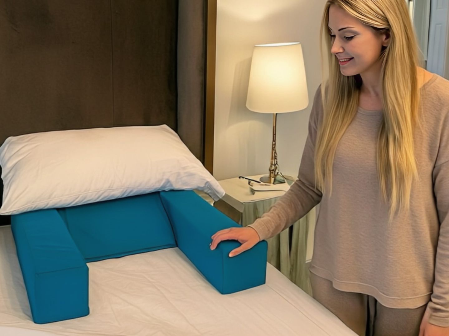 Woman placing Restore You therapeutic support pillow on bed showing easy setup to sleep in your own bed after shoulder surgery