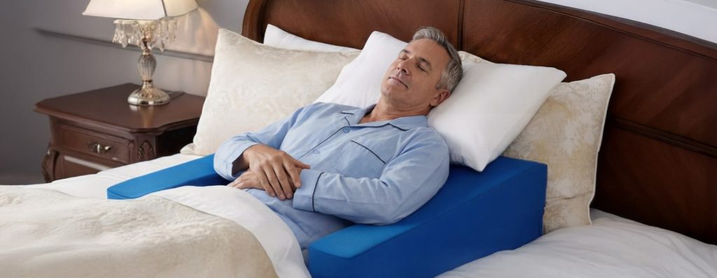 Man sleeping comfortably on Restore You shoulder surgery recovery pillow in bed demonstrating proper post-operative positioning before surgery