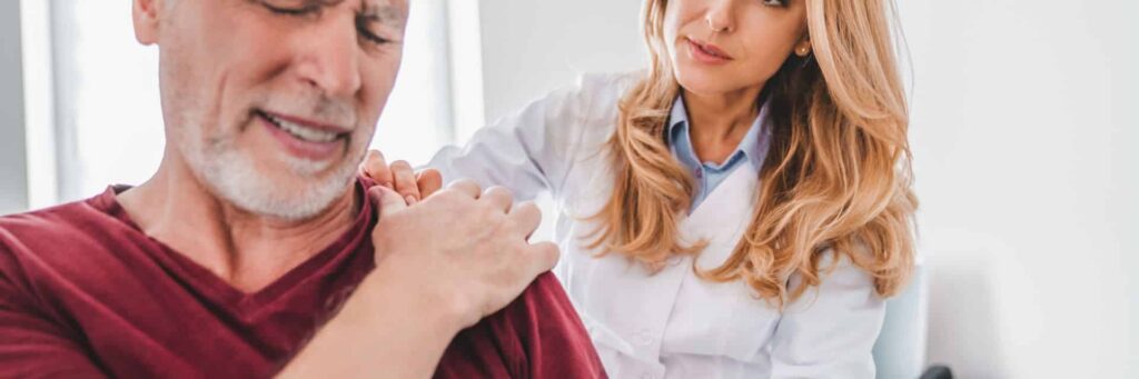 Male patient experiencing shoulder pain during consultation with healthcare provider about can't sleep after shoulder surgery