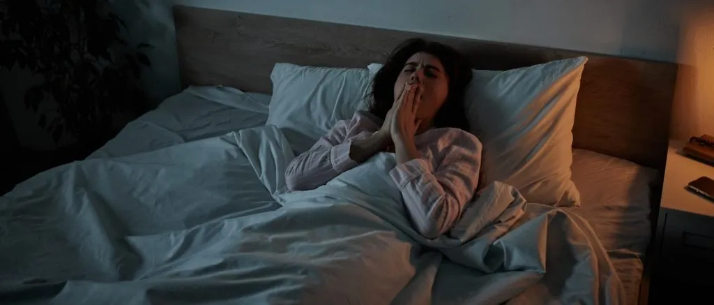 Woman experiencing insomnia and anxiety in bed at night illustrating Mental Health After Surgery challenges and sleep disruption during post-surgical recovery